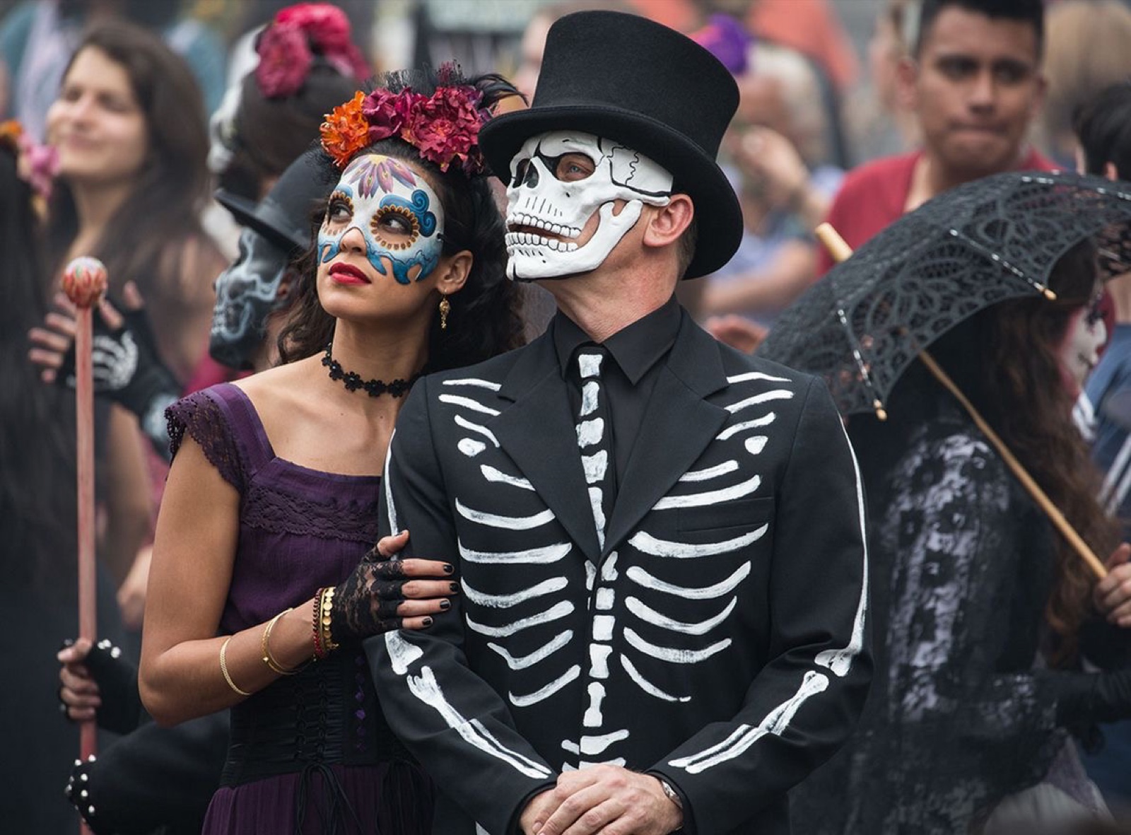 Couple in skull make-up and a skeleton suit at the parade
